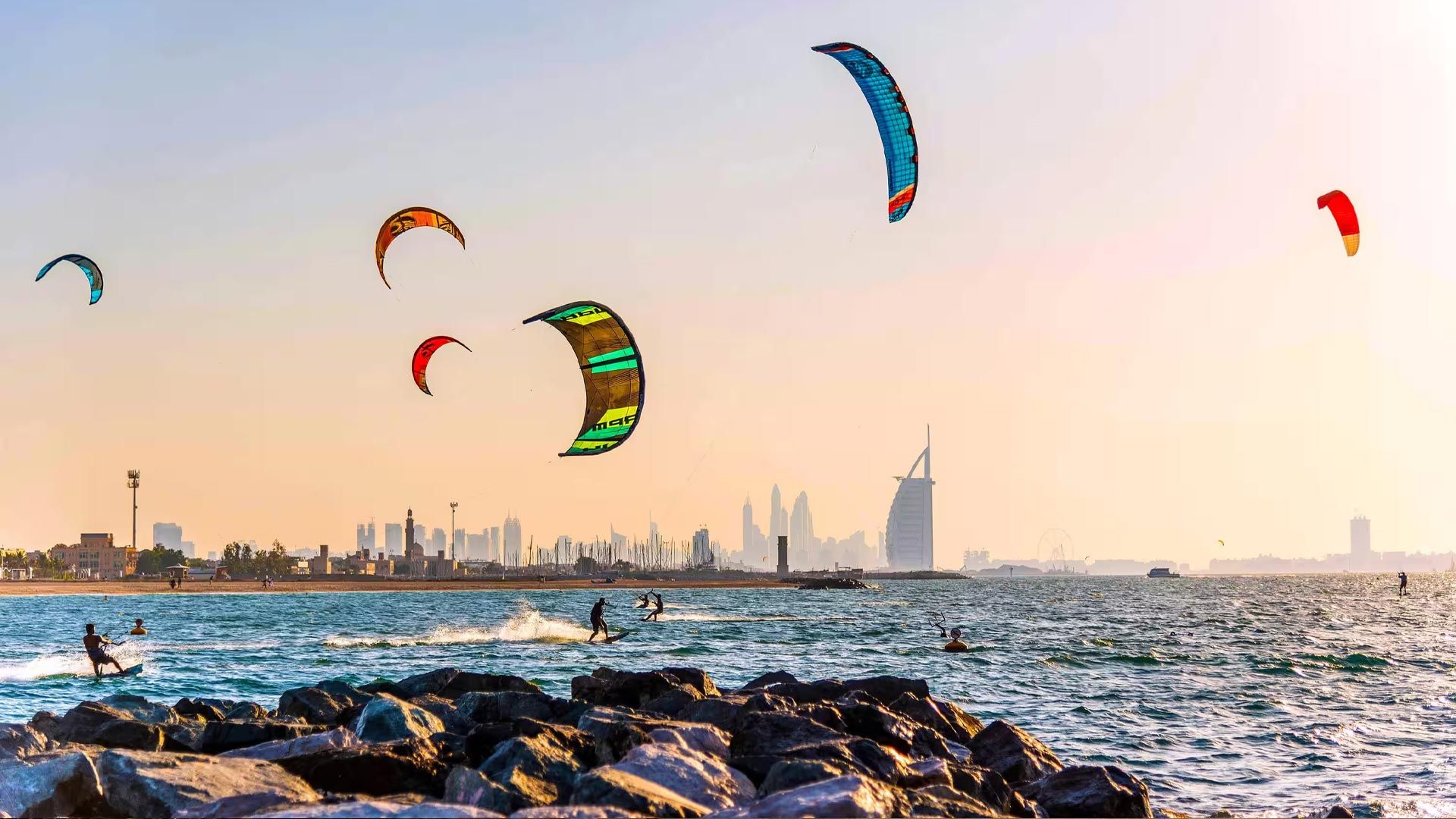 Kitesurfers off the Jumeirah coastline with Burj Al Arab and the Dubai skyline behind